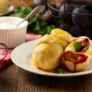 knedle ze śliwkami ze śmietaną i cukrem