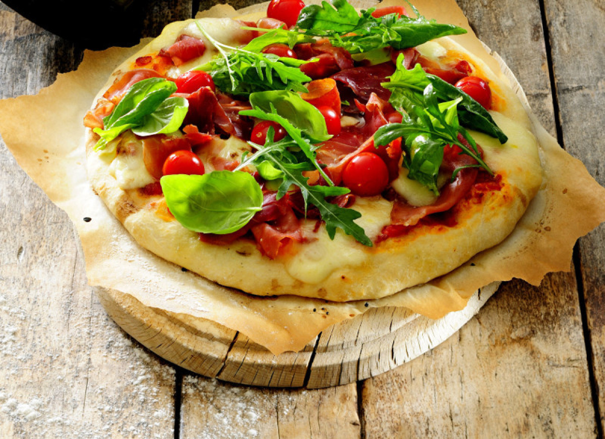 Pizza z prosciutto i zielonymi liśćmi