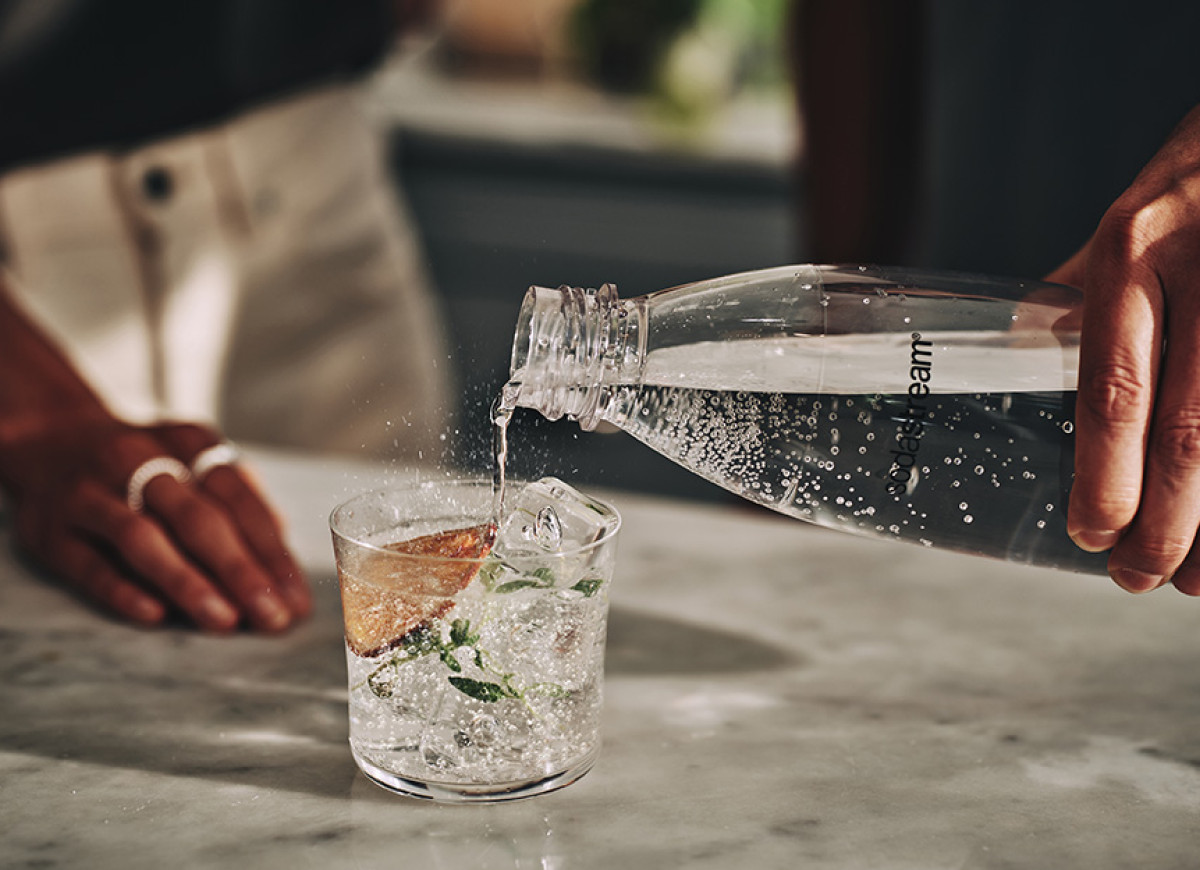 Nalewanie wody gazowanej do szklanki drinkówki - tytułowa.