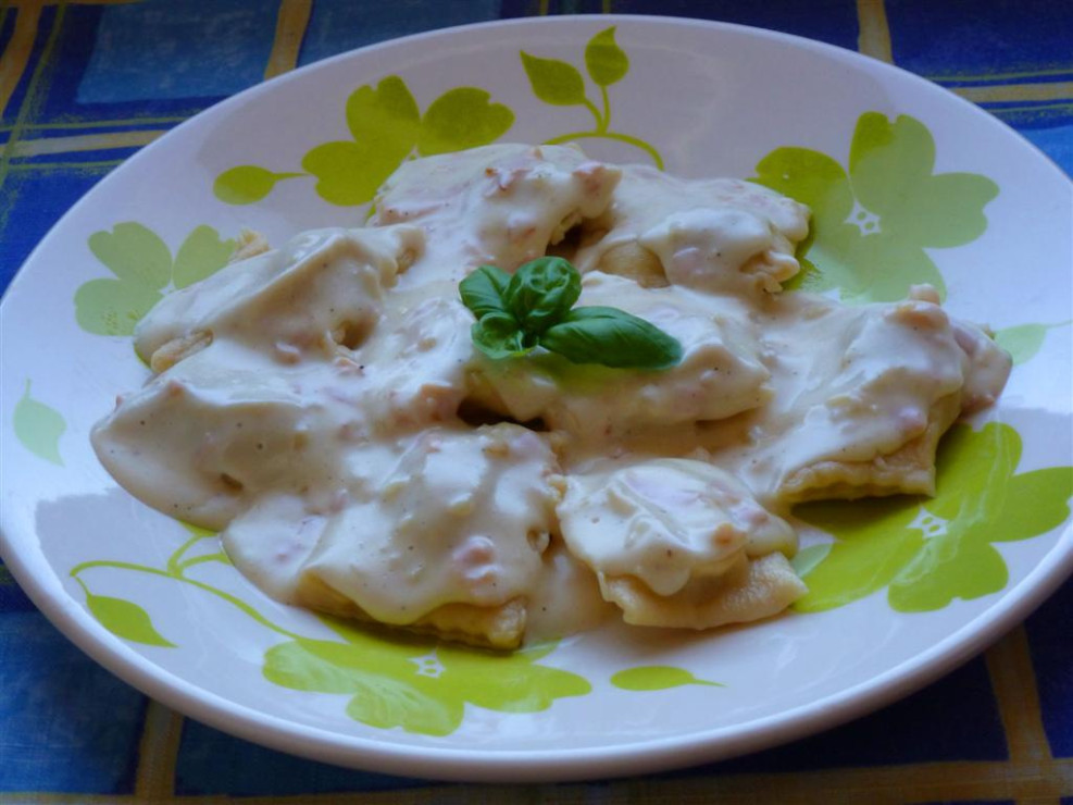 Ravioli pieczarkowe w sosie serowym z szynką i cebulą